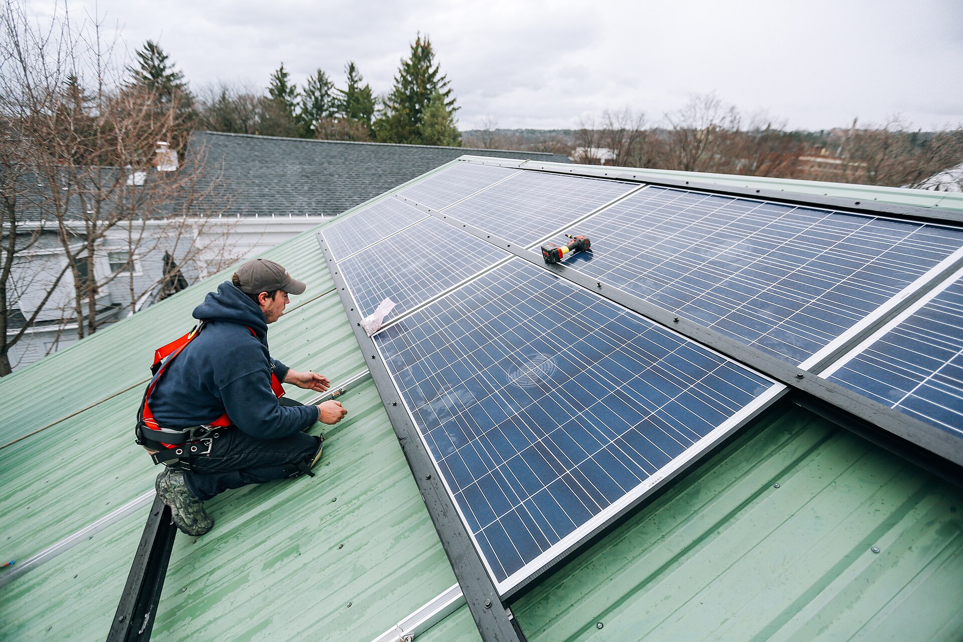 Technicien en équipement de sécurité travaillant sur des panneaux solaires en toiture